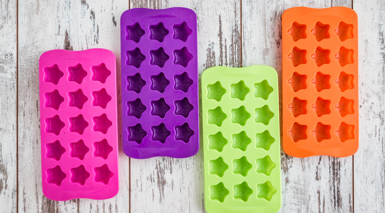 four multi-colored silicone molds laying on a wooden surface