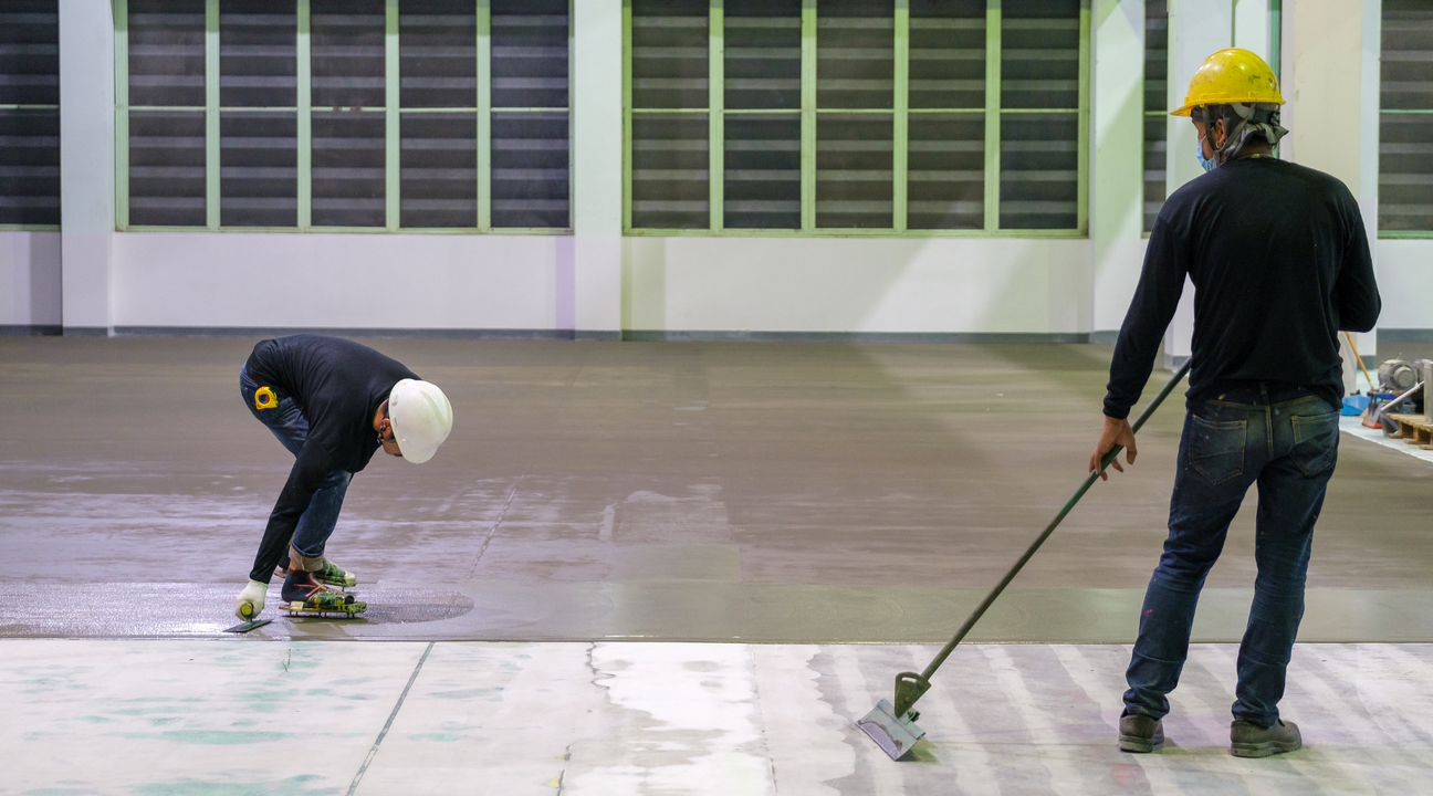  Workers applying epoxy resin on a floor in the construction industry.